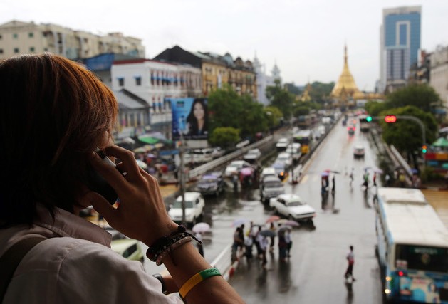A man talks on a mobile phone as he looks towards the Sule Pagoda in downtown Yangon, Myanmar. Photographer: Dario Pignatelli/Bloomberg